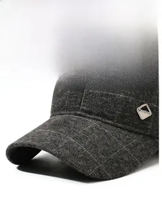 Dettaglio del berretto grigio che mostra il tessuto tweed e la placchetta in metallo