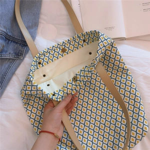 Détail du cabas en toile avec bouton-pression intérieur et bandoulière en cuir
