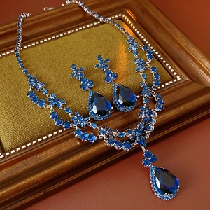 Detail of luxury zircon flower drop pendant necklace and earring set on a vintage frame