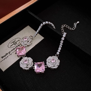 Detail of silver bracelet with pink gemstones and flower design in black velvet box