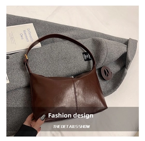 Detail of dark brown vintage faux leather tote with adjustable strap and visible stitching