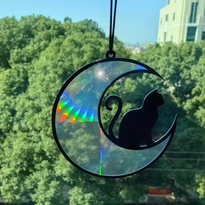 Rainbow sun catcher detail with black cat on crescent moon silhouette reflecting prism light