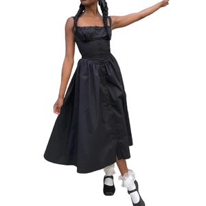 Détail d'une robe longue noire ajustée avec corsage boutonné et ourlet plissé à volants