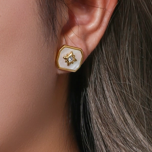 Macro shot of 18K gold-plated starburst earring with white shell inlay on model