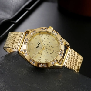 Detail of gold quartz watch featuring a crystal bezel and milanese mesh bracelet strap