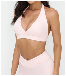 Dettaglio del reggiseno sportivo rosa con scollo a V e leggings yoga con vita incrociata