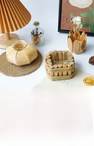 Detail view of rustic driftwood candle holders with glass inserts on a white table