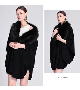 Detail view of black knit shawl cardigan featuring a thick faux fox fur collar and cape sleeves