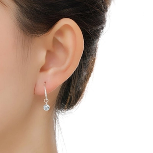 Close-up of S925 sterling silver dangle earring with a sparkling round diamond on ear