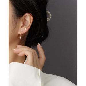 S925 sterling silver gold clover earrings with inset crystals worn by a model