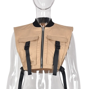 Detail of khaki techwear vest featuring black straps, plastic buckles, and cargo pockets