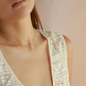 Elegant 18k gold plated titanium bow necklace set for women shown on a model