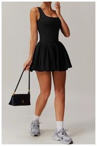 Full view of black sleeveless tennis dress with pleated skirt and athletic sneakers