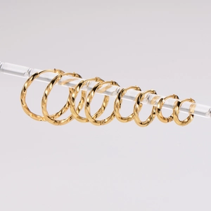 Minimalist gold twist hoop earrings in various sizes hanging on a display stand