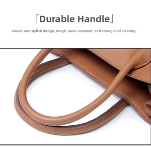 Detail of durable leather handles with clean stitching on a brown vintage tote bag