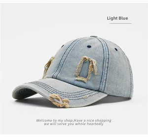 Detailed macro view of distressed denim fabric with frayed holes on light blue baseball cap