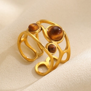 Golden hollow bangle with three oval tiger eye stones and adjustable open cuff design