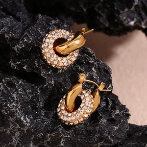 Detail of 18K gold-plated double-loop earrings with pavé rhinestones on black rock