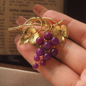 Vintage style gold grape brooch with purple gemstones and detailed leaf texture