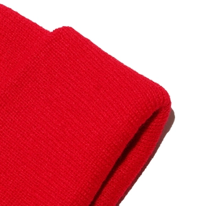 Close-up of bright red ribbed knit fabric texture on a winter beanie hat