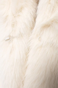 Detail of white faux fur coat featuring soft texture and two loop button closures
