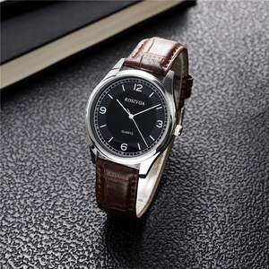 Detailed macro shot of the black dial with silver steel case and leather strap