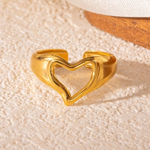 Close-up of golden hollow heart ring with adjustable band and polished finish