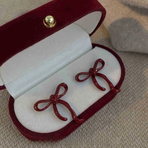 Detail view of dark red bow earrings with size measurements of 2.5cm by 2.0cm