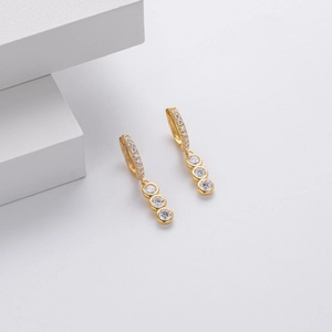 Detail view of gold S925 silver drop earrings featuring triple round bezel-set zircon stones