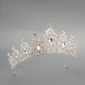 Detailed view of silver bridal crown featuring intricate scrollwork and crystal rhinestones