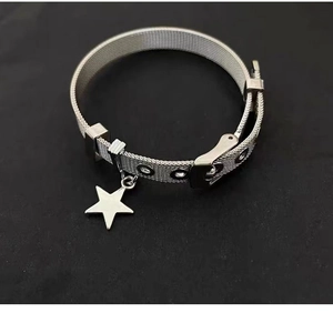 Détail d'un bracelet ceinture en maille argentée avec boucle et breloque étoile