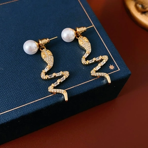 Detail of 14K gold plated snake earrings with shimmering zircons and pearls