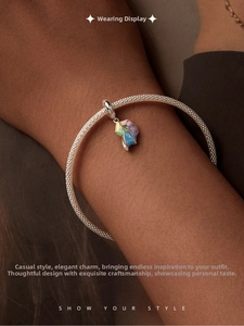 Vue détaillée d'un bracelet tressé en argent avec pendentif coquillage coloré au poignet