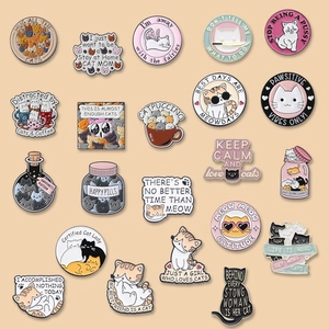 Assorted collection of 22 cute cat enamel pins and metal badges on orange background