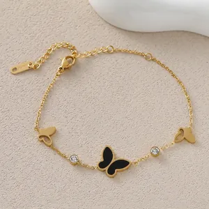 Close-up of gold butterfly bracelet featuring black enamel pendant and 18KGP mark