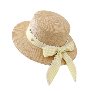 Women's boater straw hat with yellow plaid ribbon bow and golden V-shaped ornament