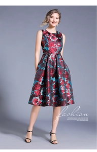 Detailed close-up of dark floral jacquard dress with red blossoms and silk-like texture