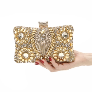 Macro detail of luxury gold evening clutch with sparkling rhinestones and crystal clasp