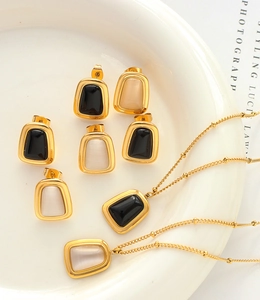 Close-up of vintage gold opal jewelry set featuring square pendants and earrings