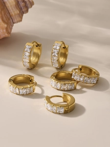 Detail of 18k gold plated huggie earrings with square cut clear zirconia stones