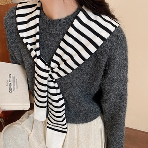 Detailed texture of black and white striped knit shawl accessory for layering over sweaters
