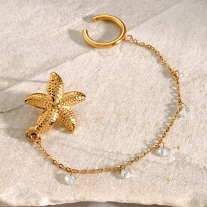 Detail of 18k gold starfish ear cuff featuring a fine chain and five sparkling zircons