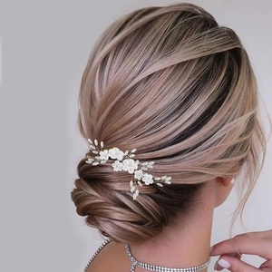 Detail of white clay flowers and pearls bridal hair comb on model hairstyle