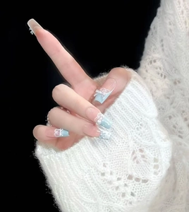 Détails de faux ongles en dentelle bleue avec nœuds 3D, perles et paillettes forme coffin