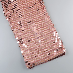 Macro detail of shimmering rose gold sequins densely stitched on fine mesh fabric
