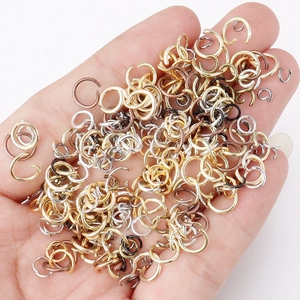 Handheld view showing various sizes of colorful metal jump rings for DIY jewelry making