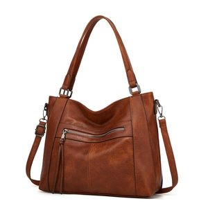 Detail view of brown vintage PU leather tote bag with fine stitching and adjustable strap