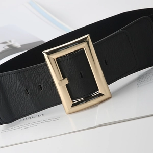 Detail of black lychee leather elastic waist belt with large gold rectangular buckle