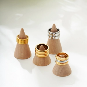 Detail of mixed gold and silver tiered rings displayed on elegant wooden jewelry cones