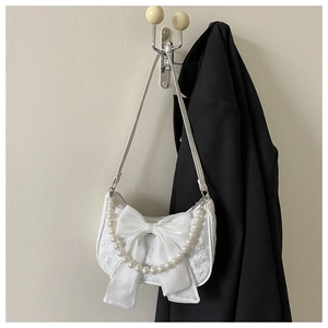 White pleated shoulder bag featuring a large silk bow and decorative faux pearl chain